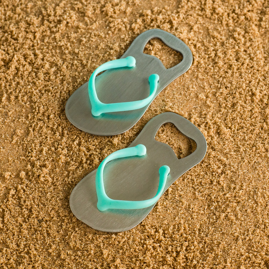 Product photography of flip flop bottle opener on sand